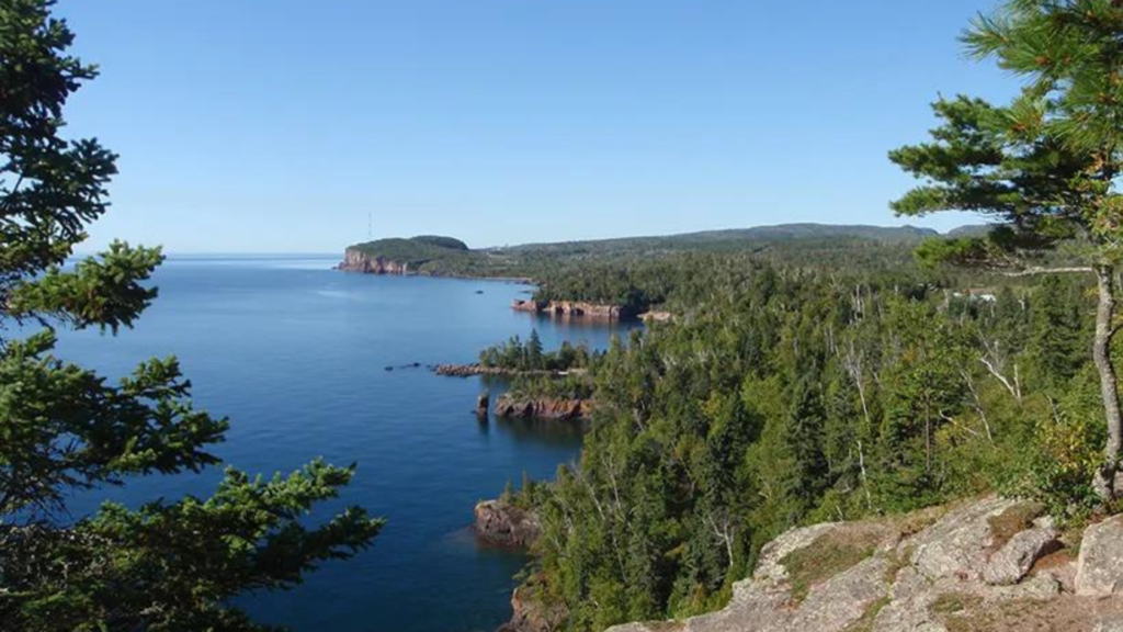 A panoramic view of Lake Superior with hints of its diverse ecosystem, representing its rich natural history.